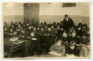 Panevėžio pradinės mokyklos Nr. 1 II-ojo skyriaus mokiniai dailyraščio pamokoje su mokytoju Vladu Paulausku. Fotogr. A. Patamsio. 1931 m. PAVB RKRS F8-637