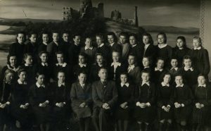 Panevėžio mergaičių gimnazijos VII kl. moksleivės su direktoriumi Broniumi Juška ir mokytoja Elena Gabulaite. Panevėžys. 1945-1946 m.m. PAVB RKRS F9-1245