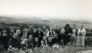 Panevėžio miesto pradinės mokyklos Nr. 1 moksleiviai ir mokytojai ekskursijoje po Anykščių kraštą. Už moksleivių iš kairės stovi pedagogai Motiejus ir Petronėlė Lukšiai. 1948 m. PAVB F68-118