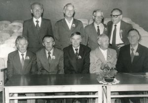 Ukmergės valstybinės mokytojų seminarijos I-osios laidos (1940 m.) absolventų susitikimas po 45 metų. 1-oje eilėje iš dešinės 2-as Stasys Šneideris. Ukmergė. 1985 m. Panevėžio apskrities G. Petkevičaitės-Bitės viešoji biblioteka, Stasio Šneiderio rankraščių fondas F51
