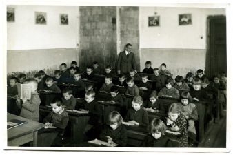 Panevėžio miesto pradžios mokyklos Nr. 1 I-ojo skyriaus mokiniai skaitymo pamokoje su skyriaus mokytoju Stanislovu Janausku. Fotogr. A. Patamsio. 1931 m. PAVB F8-637