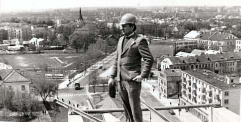 PST Specializuotos apdailos darbų valdybos Nr. 5  vyr. mechanikas Romualdas Palionis ant statomo 13-os aukštų daugiabučio Panevėžyje, Vilniaus ir Basanavičiaus gatvių kampe, stogo. Apie 1979 m.