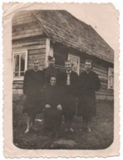 Petriškių kaime (Rokiškio raj.) prie namų. Sėdi Elenos motina Konstancija Šniokaitė-Mezginienė, iš kairės stovi sesuo Genovaitė, brolis Algimantas, Elena ir sesuo Elvyra. 1957 m. Maironio literatūros muziejus