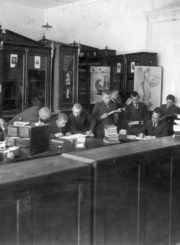 Mokytojas Jonas Sokolovas (sėdi prie stalo) Panevėžio valstybinės gimnazijos bibliotekoje su talkininkais. Fotogr. J. Žitkaus. Panevėžys. Apie 1934 m. Panevėžio Juozo Balčikonio gimnazijos istorijos muziejaus archyvas