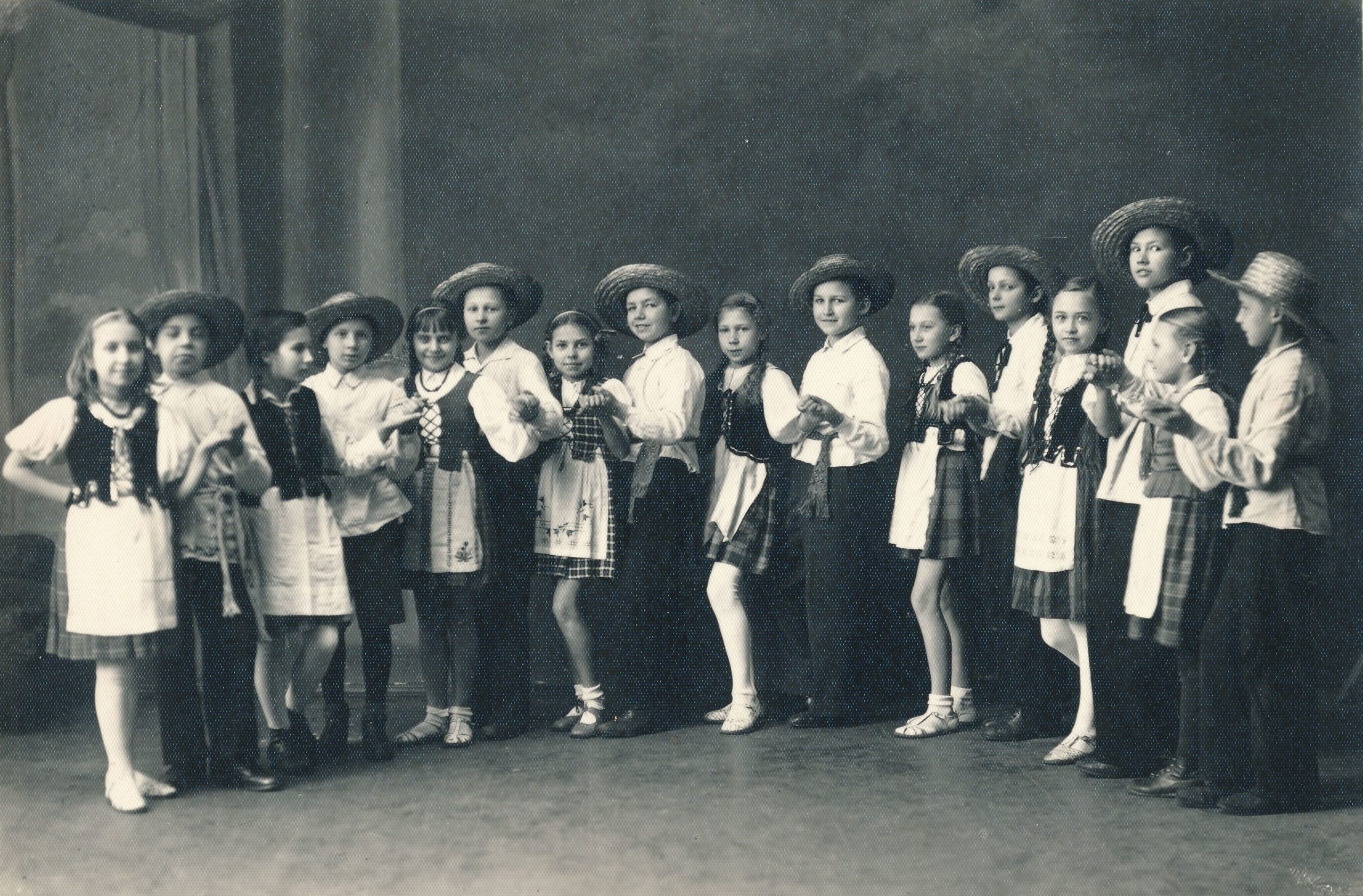 Panevėžio miesto pradžios mokyklos Nr. 1 ketvirtos klasės šokių ratelis. Iš kairės: 1-a Teresė Mikeliūnaitė. Fotogr. J. Žitkaus. 1938 m. Panevėžio apskrities Gabrielės Petkevičaitės-Bitės viešoji biblioteka, Teresės Mikeliūnaitės fondas F50-346