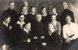 Kunigas Jurgis Tilvytis su grupe ateitininkų. 2-oje eilėje iš kairės: 2-as Juozas Barisas, 3-ias kun. Jurgis Tilvytis, 4-a mokytoja Sofija Barisienė. Stovi iš kairės: 3-ia Liucija Žukauskaitė (vėliau – Žilėnienė), 6-as būsimasis kunigas Karolis Garuckas. Fotogr. J. Pauros. Panevėžys. Apie 1930 m. PAVB, Julijos Žukauskaitės fondas F115-358