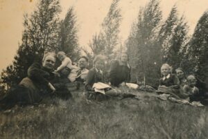 „1939 m. pavasarį Barisų ūkyje“. Iš kairės: kunigas Augustinas Liepinis, Antanukas Barisas, Juozas Barisas, Laimutė Barisaitė, Sofija Barisienė, Danutė Barisaitė, S. Barisienės motina Uršulė Stalionienė, Onutė Barisaitė. PAVB skaitmeninis archyvas