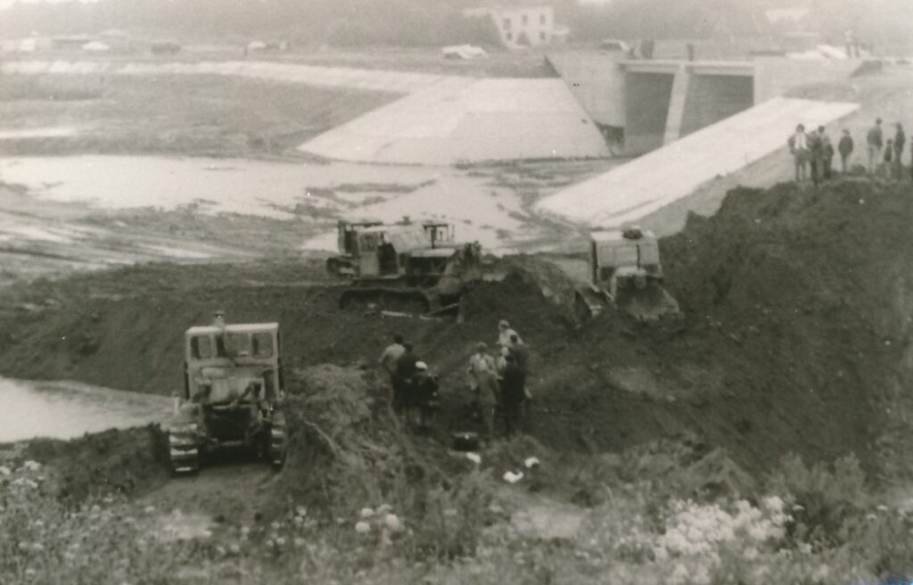 Nevėžio („Ekrano“ marių) užtvankos statyba. Statybvietėje lankosi Melioracijos statybos-montavimo valdybos administracijos atstovai. Panevėžys. Apie 1979 m. PAVB skaitmeninis archyvas