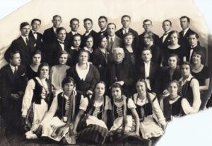 „Dainos“ draugijos Panevėžio skyriaus choras su skyriaus valdybos pirmininku kunigu Jonu Karbausku ir choro vadovu bei skyriaus valdybos vicepirmininku muziku Mykolu Karka. 1928 m. Skelbta: https://virtualios-parodos.archyvai.lt/lt/virtualios-parodos-itraukios-istorijos/34/panevezio-operetes-tevas/exh-302/draugijos-bureliai-rateliai/case-1560#slide11; LLMA, F 57, ap. 1, b. 30, l. 1