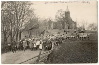 Skiemonių pavasarininkų šventės dalyvių eisena prie Skiemonių Švč. Mergelės Marijos Aplankymo bažnyčios. Nuotrauka. Skiemonys (Anykščių r.). Apie 1930 m. PAVB, Panevėžio vyskupijos kurijos skaitmeninis archyvas