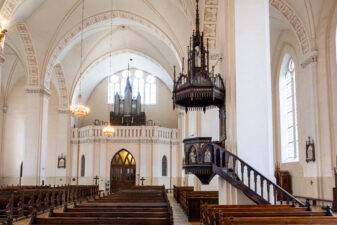 Kupiškio Kristaus Žengimo į dangų bažnyčios interjeras: sakykla, puošta smulkiais pinakliais, smailiomis arkutėmis (aut. A. Zaborskis), vargonų choras (įrengtas XX a. 6 deš.). Fotogr. G. Lukoševičius. Kupiškis. 2025 m. PAVB skaitmeninis archyvas