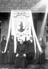 Geidžiūnų Šv. Angelų Sargų bažnyčios tretininkai su neidentifikuotu kunigu. Fotogr. P. Ločeris. Geidžiūnai (Biržų r.). XX a. 4 deš. Iš: www.limis.lt; Biržų krašto muziejus „Sėla“, pirm. apsk. nr. BKM GEK 19263