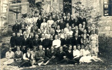 Panemunio parapijos jaunimas su klebonu Vincentu Norkumi (centre) prie Švč. Trejybės bažnyčios. Panemunis (Rokiškio r.). 1933 m. Iš: www.limis.lt; Rokiškio krašto muziejus, inv. nr. RKM F 1781